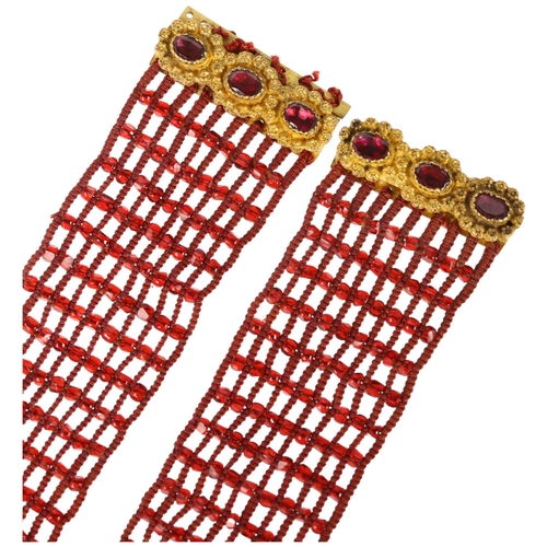 1135 - A pair of Georgian garnet beaded cuff bracelets, circa 1800, the gilt-metal garnet floral clasps sus... 