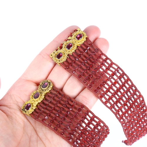 1135 - A pair of Georgian garnet beaded cuff bracelets, circa 1800, the gilt-metal garnet floral clasps sus... 