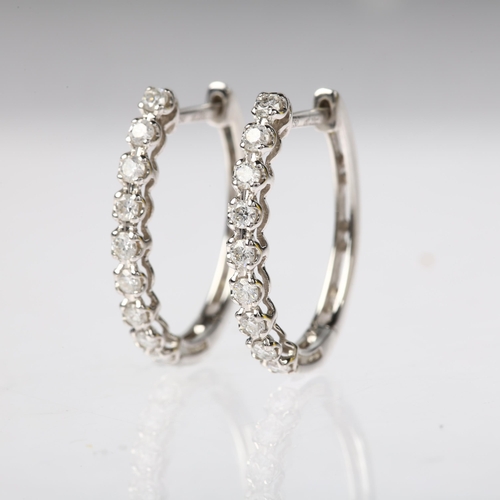 1197 - A pair of 18ct white gold diamond hoop earrings, claw set with modern round brilliant-cut diamonds a... 