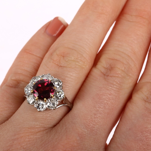 1201 - A fine pyrope garnet and diamond flowerhead cluster ring, claw set with 2ct round-cut garnet surroun... 