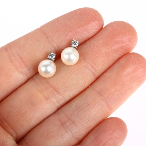 1207 - A pair of 18ct white gold whole pearl and diamond earrings, each claw set with 0.07ct modern round b... 