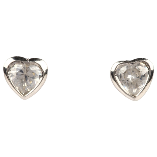 1212 - A pair of solitaire diamond heart earrings, rub-over set with heart-cut diamonds with stud fittings,... 