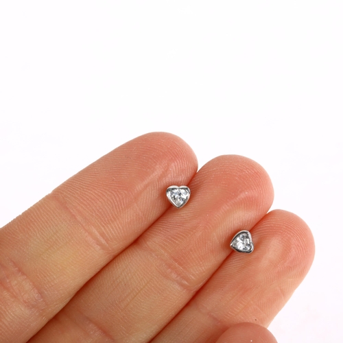 1212 - A pair of solitaire diamond heart earrings, rub-over set with heart-cut diamonds with stud fittings,... 