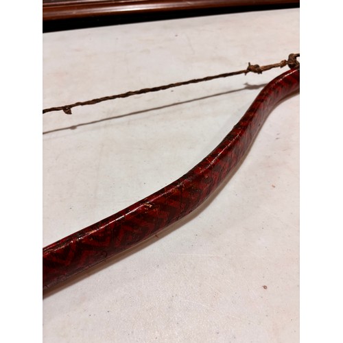 94 - A traditional Mongolian bow,  wood construction with painted chevron detail and leather strapping, l... 