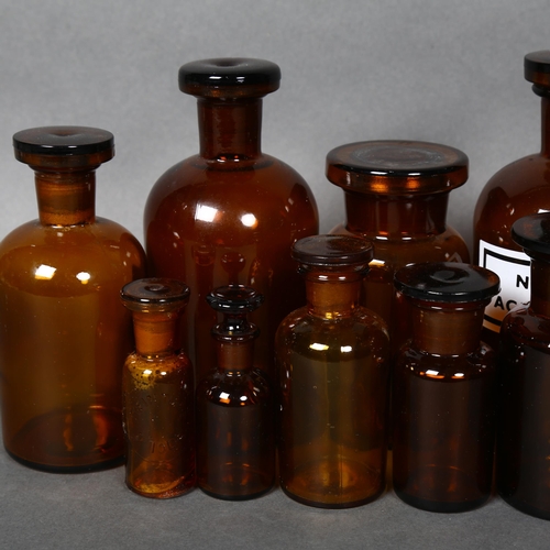 174 - A collection of Mid-century Amber apothecary bottles, various sizes, all including stoppers, largest... 