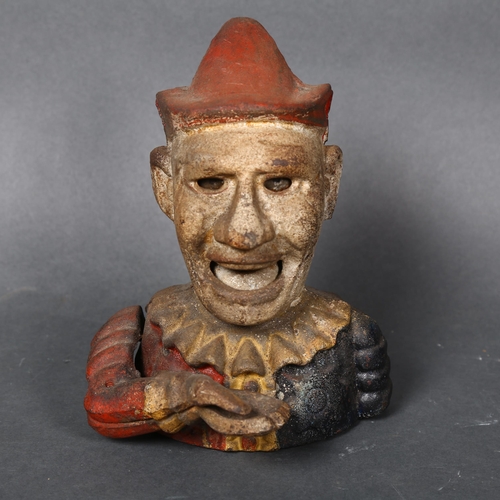 177 - A Vintage cast iron money box in the form of a jester or clown, coin is placed in hand and is fed vi... 