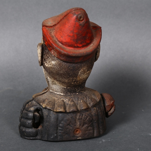 177 - A Vintage cast iron money box in the form of a jester or clown, coin is placed in hand and is fed vi... 