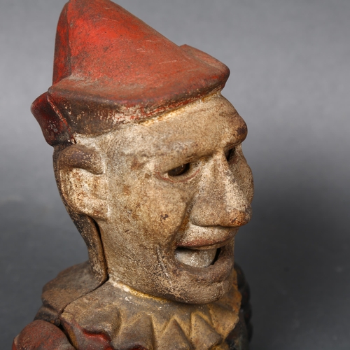 177 - A Vintage cast iron money box in the form of a jester or clown, coin is placed in hand and is fed vi... 