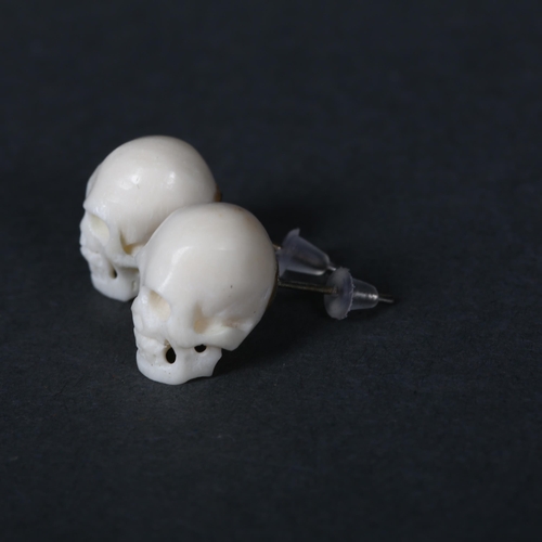 326 - A pair of carved Water Buffalo bone 'Skull' stud earrings