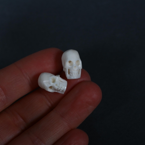 326 - A pair of carved Water Buffalo bone 'Skull' stud earrings