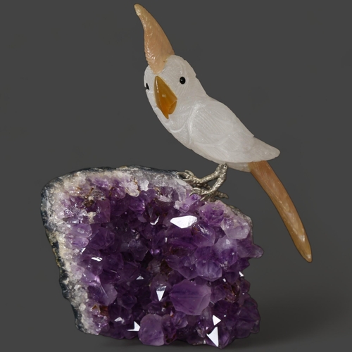 353 - A polished Amethyst crystal geode, surmounted by a quartz Parrot, height 19cm.