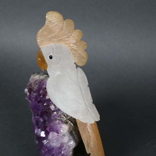 353 - A polished Amethyst crystal geode, surmounted by a quartz Parrot, height 19cm.