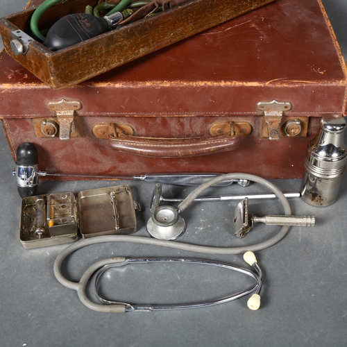 435 - A vintage Doctors medical bag, containing various vintage medical instruments including a stethoscop... 