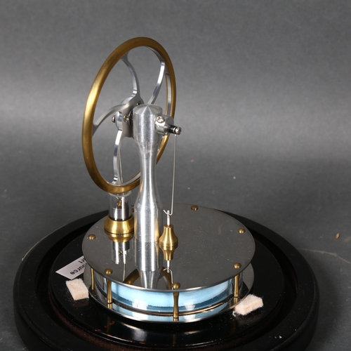 439 - A Stirling engine, mounted under glass dome on stand, height 24cm overall.