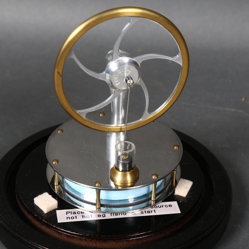 439 - A Stirling engine, mounted under glass dome on stand, height 24cm overall.