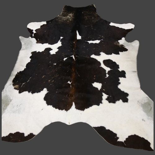 367 - Taxidermy - a Large Black and White Cow Skin Hide Rug, approximately 190cm x 150cm.