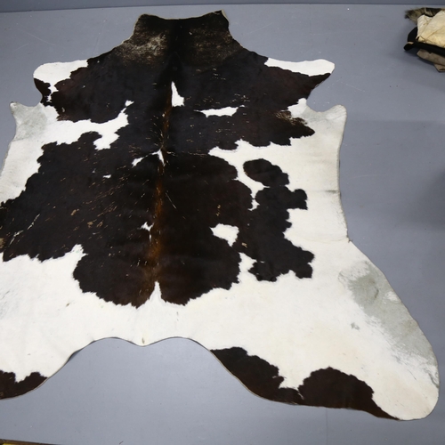 367 - Taxidermy - a Large Black and White Cow Skin Hide Rug, approximately 190cm x 150cm.