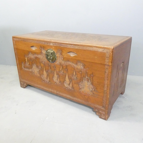 2698 - A Chinese camphorwood chest, with brass lock and relief carved decoration. 105x58x52cm