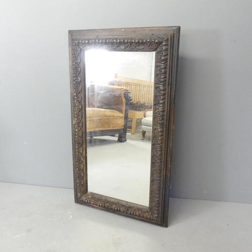 2702 - An antique rectangular oak framed wall mirror with carved decoration. 61x104cm.