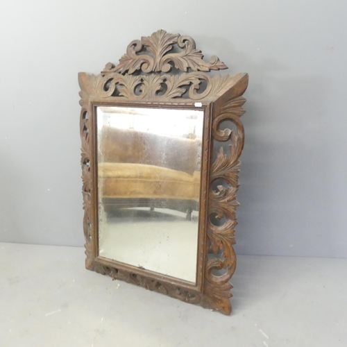 2703 - A French rectangular oak framed wall mirror with carved and pierced foliate decoration. 73x120cm.