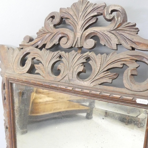 2703 - A French rectangular oak framed wall mirror with carved and pierced foliate decoration. 73x120cm.