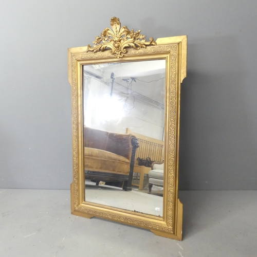 2704 - A modern continental style gilt-painted wall mirror with carved decoration. 69x112cm.