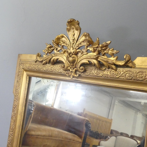 2704 - A modern continental style gilt-painted wall mirror with carved decoration. 69x112cm.