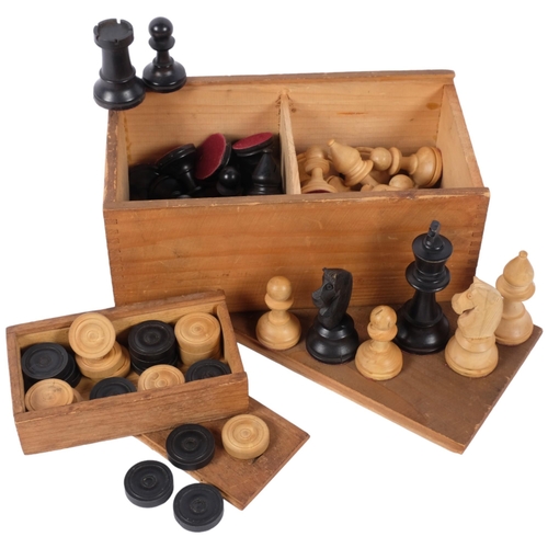 679 - A box of turned wood chessmen, and a box of draughts pieces