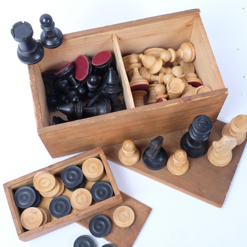 679 - A box of turned wood chessmen, and a box of draughts pieces