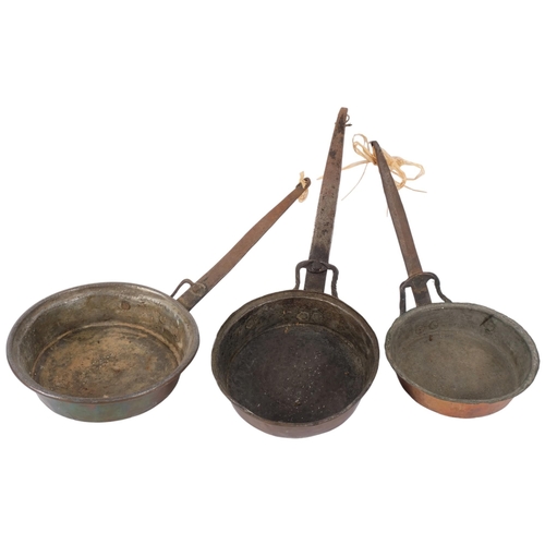 686 - A graduated set of Antique copper pans with iron handles, largest 20cm diameter