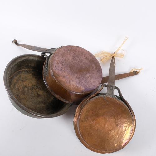 686 - A graduated set of Antique copper pans with iron handles, largest 20cm diameter