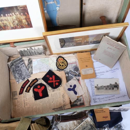 153 - A collection of military postcards, pictures, booklets, buttons, buckle, canvas bag, etc, in a leath... 