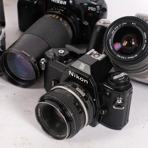 242 - A selection of Vintage cameras and associated lenses, including an Olympus OM10, and various Nikon c... 