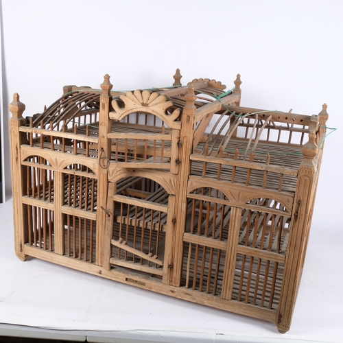 283 - A large palace design wooden hanging bird cage, with figural guard to front door, 76cm x 51cm x 49cm