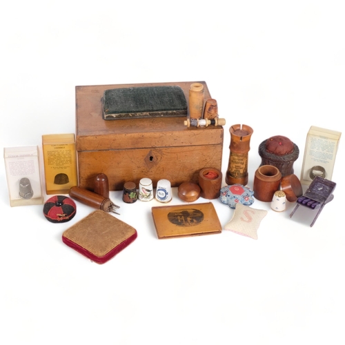 377 - A Victorian walnut sewing box and contents, including treen sewing boxes, pin cushions, thimbles, et... 