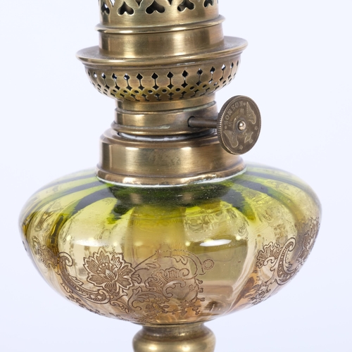 65 - A small gilt-metal oil lamp on an onyx and turned wood base,  with an engraved green glass font, H34... 