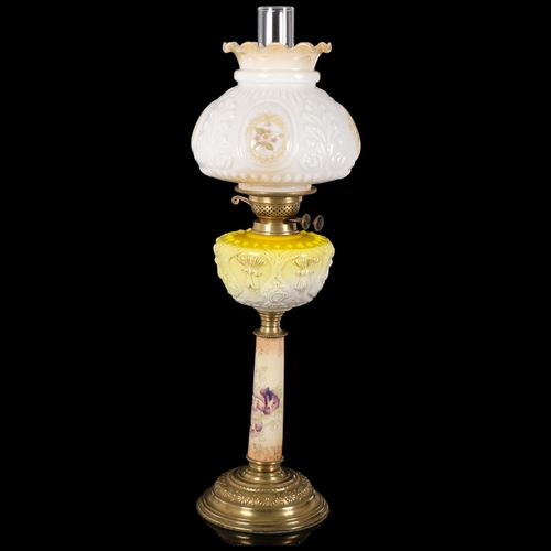 66 - An Antique brass and glass oil lamp, with a white embossed and painted shade with yellow glass and g... 