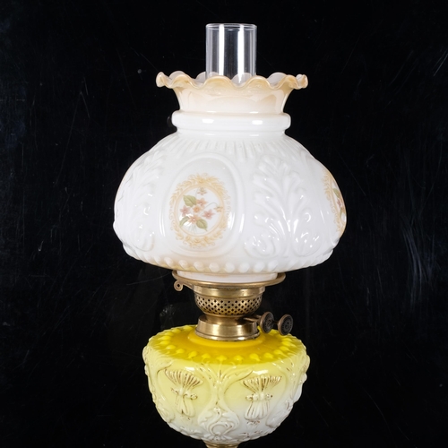 66 - An Antique brass and glass oil lamp, with a white embossed and painted shade with yellow glass and g... 