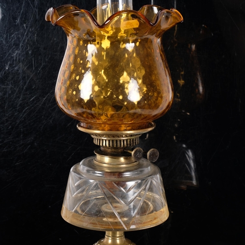 71 - An Art Nouveau copper and brass oil lamp, with an amber frilled edge shade, and clear glass font, H6... 