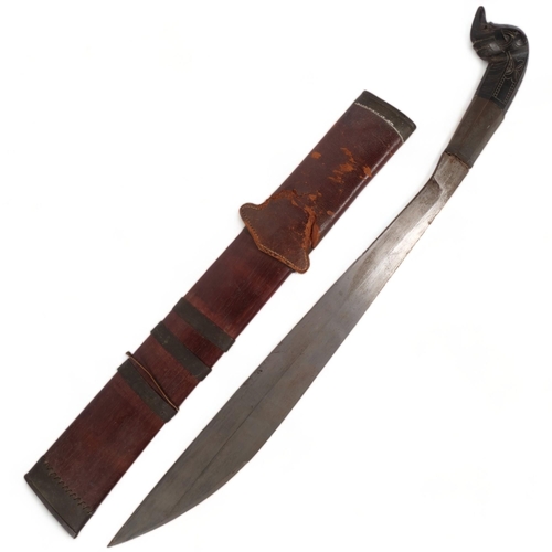 97 - A Philippine machete, with carved animal handle with a leather and bamboo scabbard, blade length 45c... 