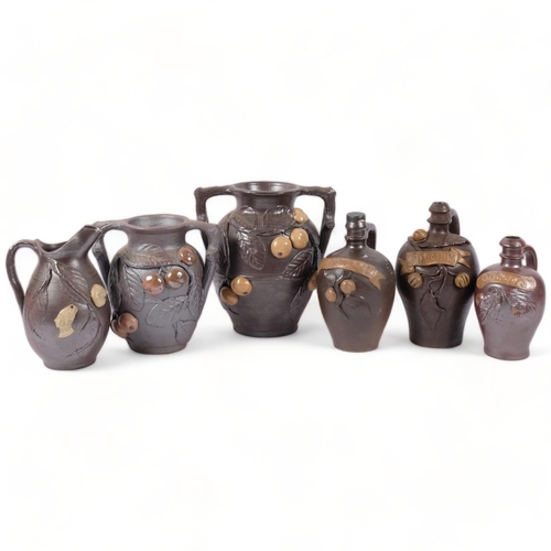 701 - 3 terracotta Calvados jugs with applied decoration, 2 similar vases and a jug with applied fruit and... 