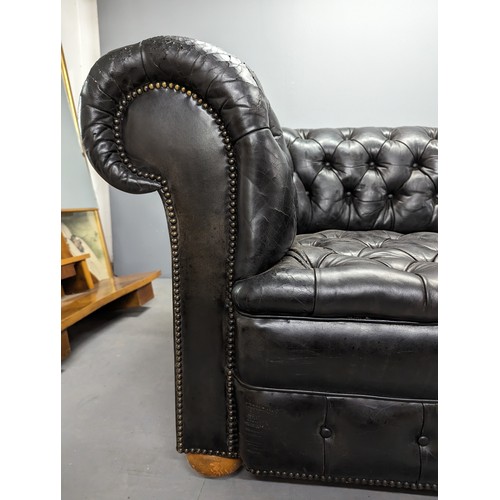 2712 - An vintage black leather Chesterfield style sofa. Overall 230x75x95cm, seat 163x42x60cm.