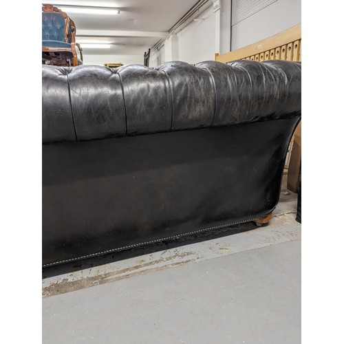 2712 - An vintage black leather Chesterfield style sofa. Overall 230x75x95cm, seat 163x42x60cm.