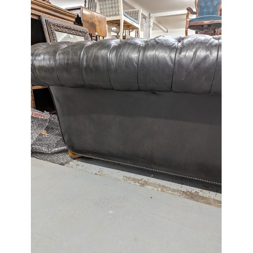 2712 - An vintage black leather Chesterfield style sofa. Overall 230x75x95cm, seat 163x42x60cm.