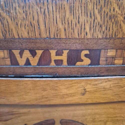 44 - An Art Deco oak and marquetry decorated magazine rack with brass handles, monogramed WHS, H45cm