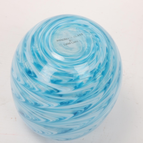 179 - LIAM CAREY, a hand made swirled blue/white glass vase, makers label to base, height 14cm