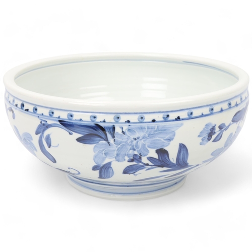 200 - JONATHAN CHISWELL JONES, a studio pottery porcelain bowl with blue and white floral painted glaze, m... 