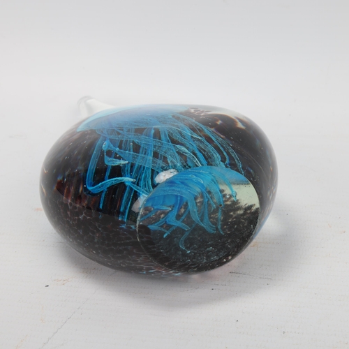 313 - An elongated hand made glass paperweight, with internal blue jellyfish on spotted amethyst backgroun... 