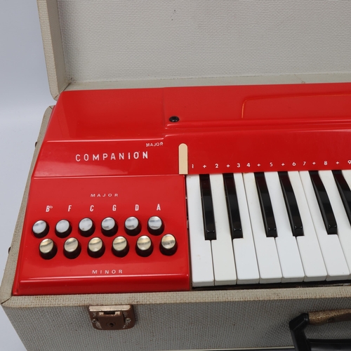 315 - A mid 20th century Italian Companion electric keyboard, red plastic in original fixed carry case and... 