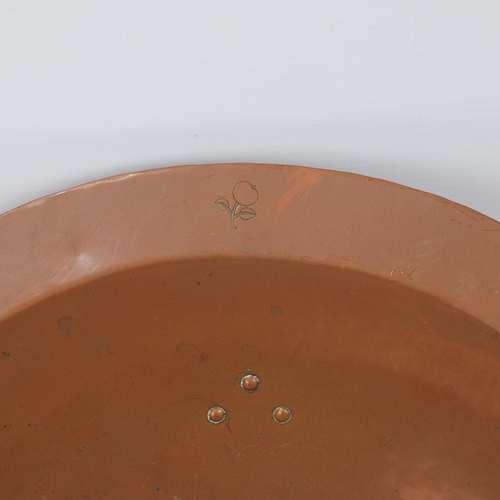 98 - An early 20th century planished copper fruit bowl by the Birmingham Guild Ltd with riveted brass fee... 